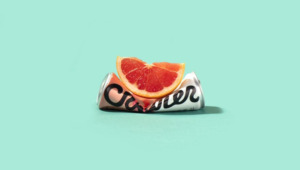 A horizontally smashed can of Crawler Citrus topped with a grapefruit slice